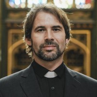 Father Monahan Christian priest standing by the altar